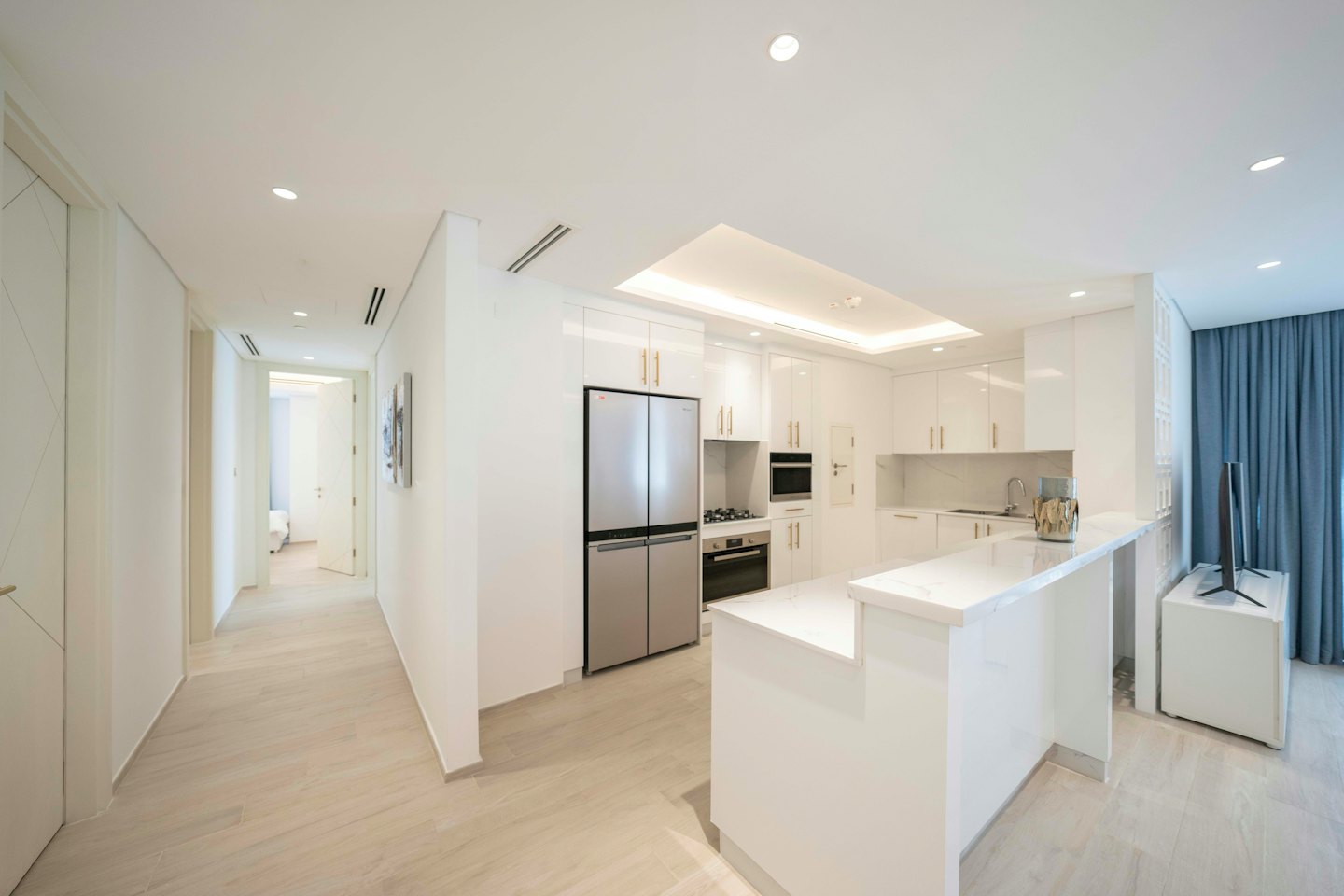 Cucina moderna open space con mobili laccati lucidi e piano in marmo.
